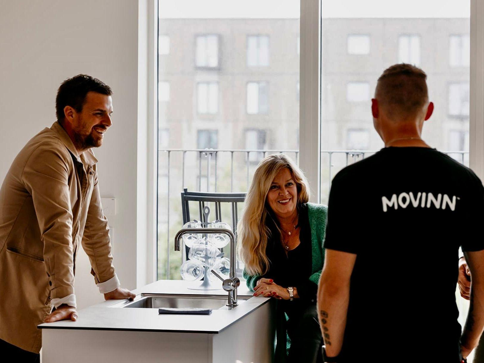 The moving team laughing together with a client in one of their apartments