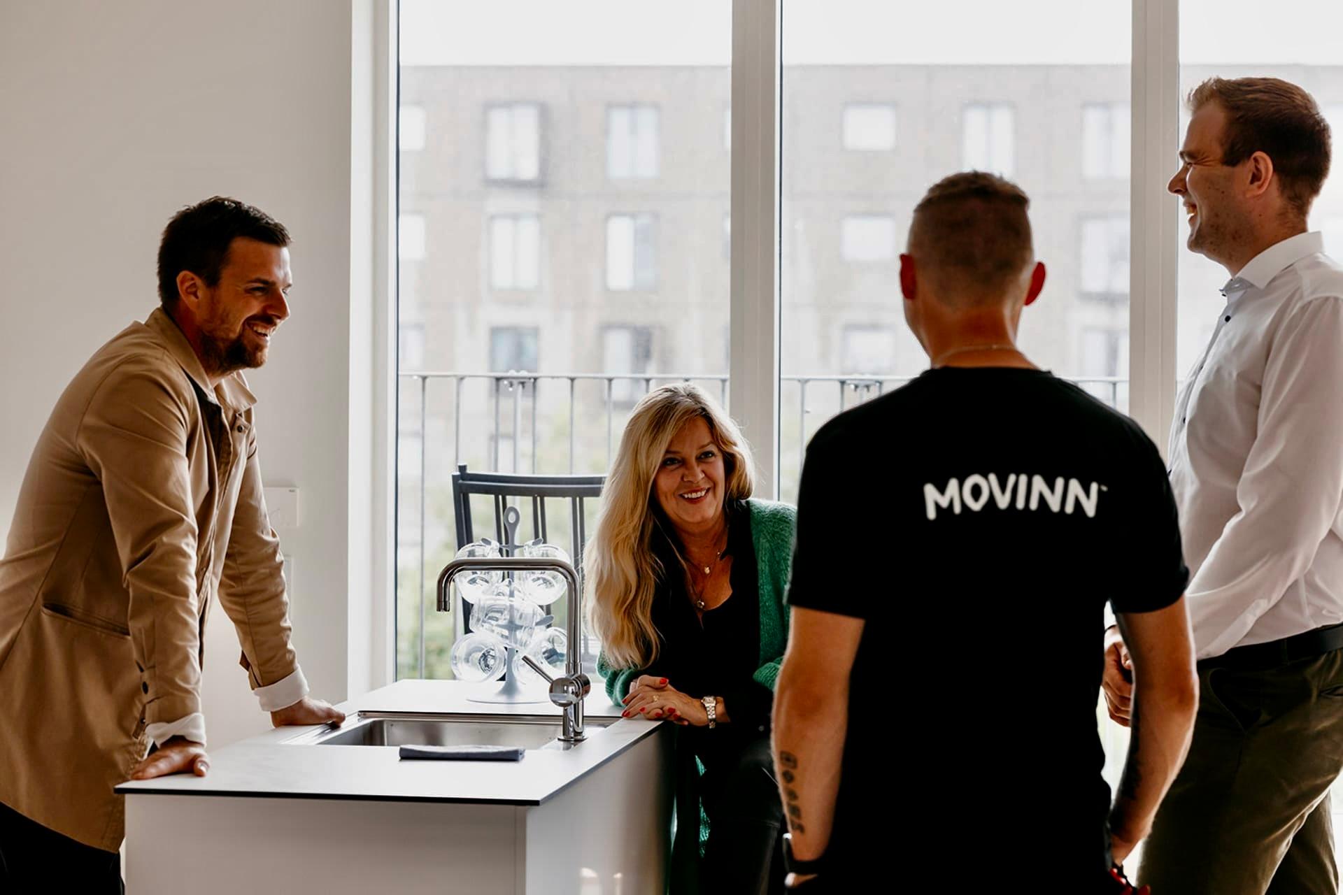 The moving team laughing together with a client in one of their apartments